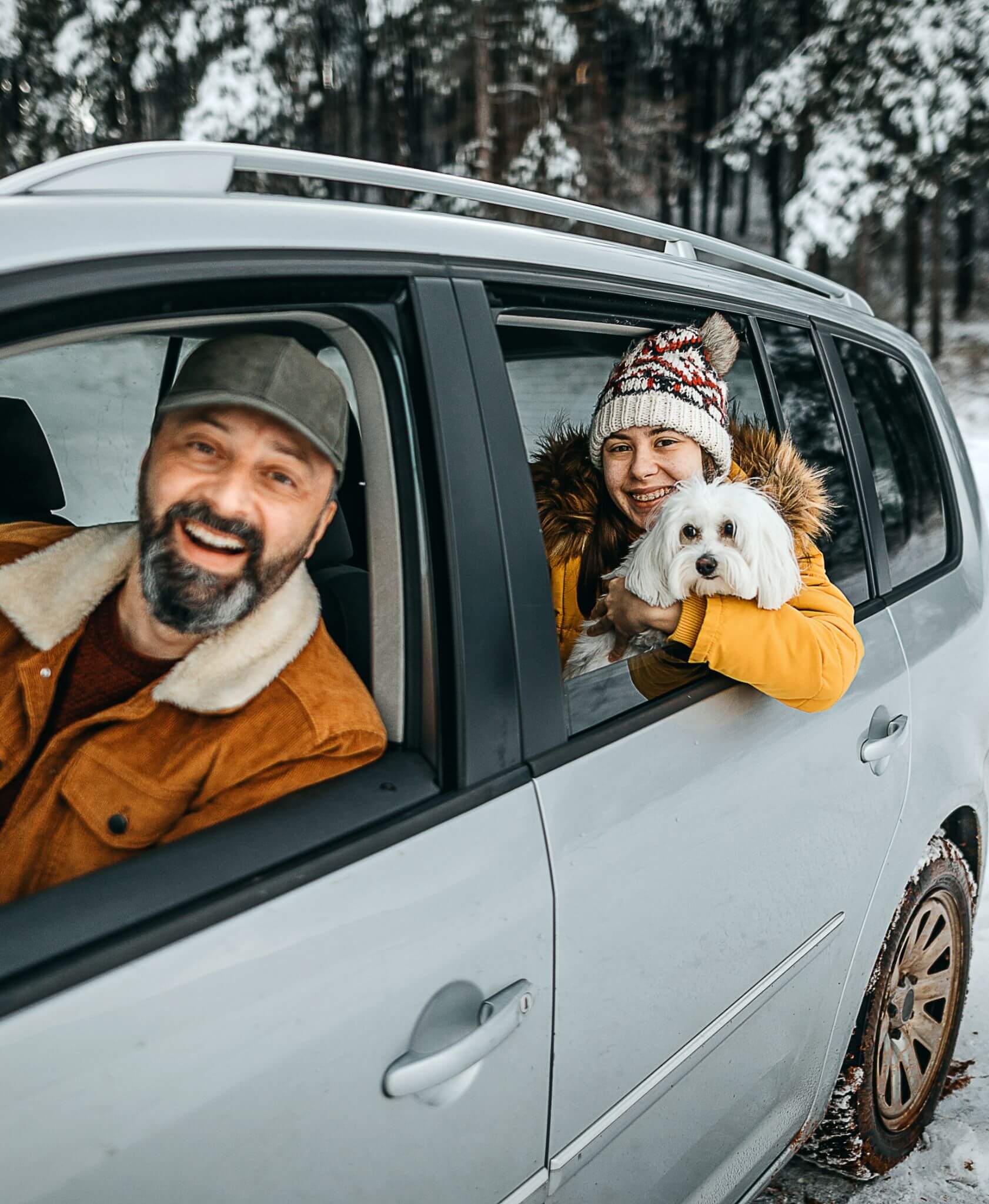 A dad and his daughter in a car during the winter